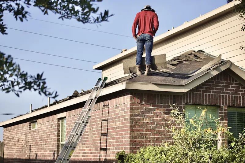 Professional roofer working on a residential roof in Celeste